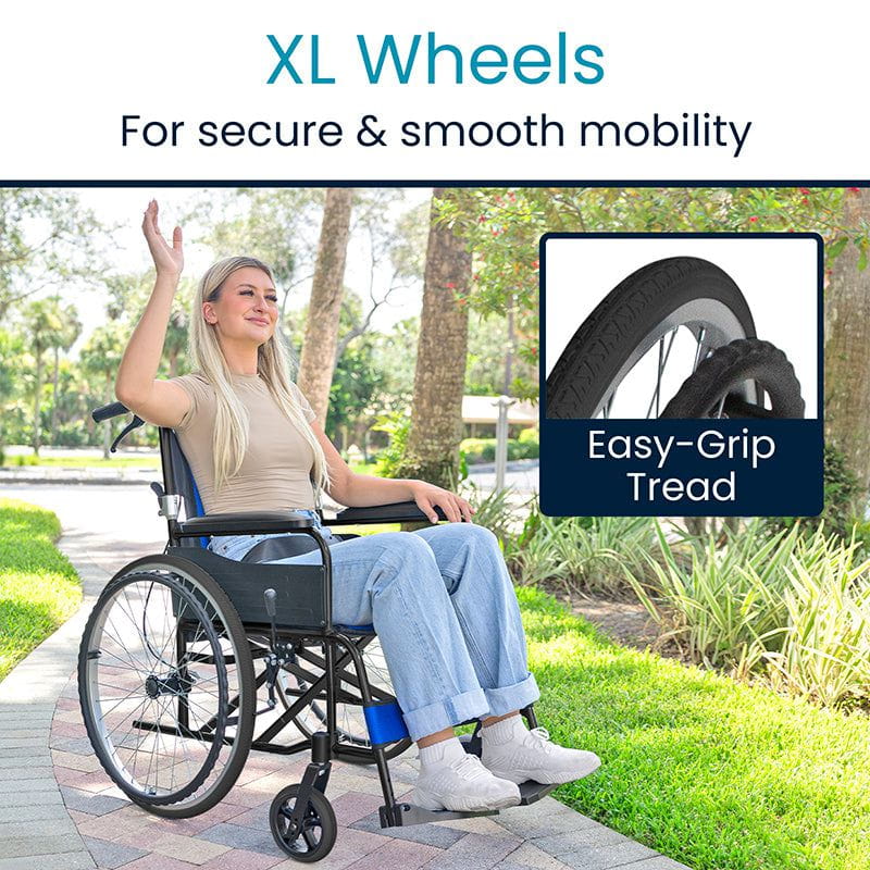 A woman in a wheelchair sits on a paved path, waving amidst lush greenery, suggesting a park setting. She's wearing a beige top and blue jeans. The wheelchair has XL wheels with easy-grip tread and a durable aluminum frame, featuring the Air Frame Wheelchair by Vive Health.