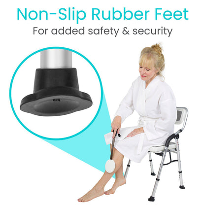 Someone in a white robe sits on a Vive Health Folding Shower Chair, using a bath sponge on their leg. A magnified view of the aluminum frame highlights the chair's non-slip rubber feet, ensuring safety and security.