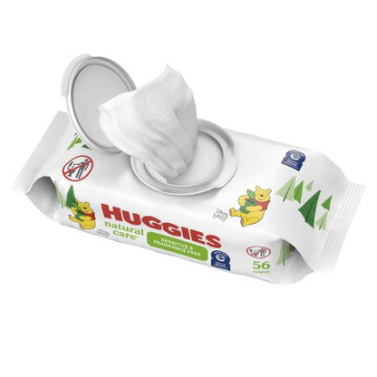 The Huggies Natural Care Baby Wipes by Kimberly Clark, featuring Winnie the Pooh illustrations, have a slightly open lid with one wipe ready. Designed for newborns and sensitive skin, these unscented wipes come in a white package with green trees and contain 56 wipes.