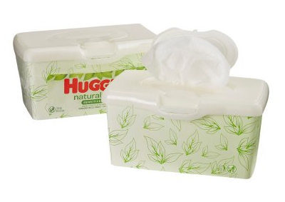 Two Kimberly Clark Huggies Natural Care Baby Wipes containers, green leaf design. The open front container exposes a tender wipe for newborns' sensitive skin, while the closed back container keeps unscented, hypoallergenic wipes fresh.