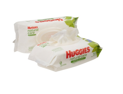 Two packages of Huggies Natural Care Baby Wipes - Unscented by Kimberly Clark are shown. One is open with a wipe protruding, ideal for sensitive newborn skin. The packaging is primarily white with green leaf designs and red branding, each hypoallergenic pack containing 56 wipes.