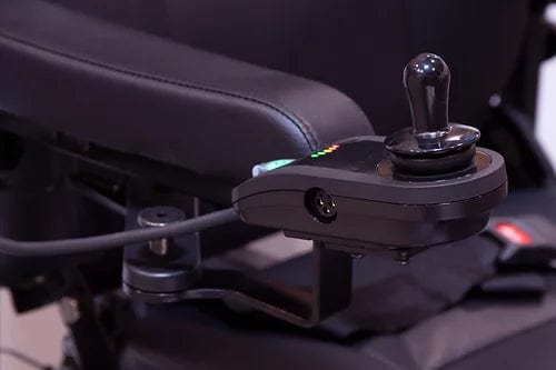 The EW-M51 Power Chair by E-Wheels features a black joystick with a spherical grip mounted on its armrest, used to control the rear-wheel drive. Colored indicator lights are visible next to the joystick.