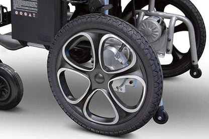 The EW-M30 Powered Wheelchair from E-Wheels showcases a sleek, modern folding design with a black and silver alloy wheel featuring thick treaded tires. Ideal for travel, it includes a smaller support wheel and visible motor mechanism.