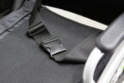 Close-up of a black seatbelt buckle on an EW-M30 Powered Wheelchair by E-Wheels. It fastens against dark fabric, with an armrest visible on the right, highlighting the design efficiency ideal for journeys.