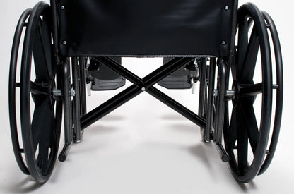 Close-up of the Traveler HD by Graham Field, a heavy-duty wheelchair viewed from the back. The image highlights its large wheels, footrests, and reinforced X-shaped frame beneath the seat. The background is a plain, white surface.