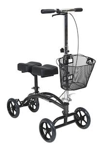 The Drive Medical Dual Pad Steerable Knee Walker, an alternative to crutches, features a black frame with four wheels, handlebars with hand grips and a brake lever for easy steering, a padded knee seat, and includes a front basket for convenience.