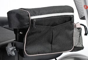 The Armrest Bag LG 14X11X4 by Drive Medical is conveniently attached to the side of a wheelchair. It features a front zipper pocket and a mesh side pocket, offering easy access and storage for personal items. This versatile bag is ideal for both wheelchairs and scooters.