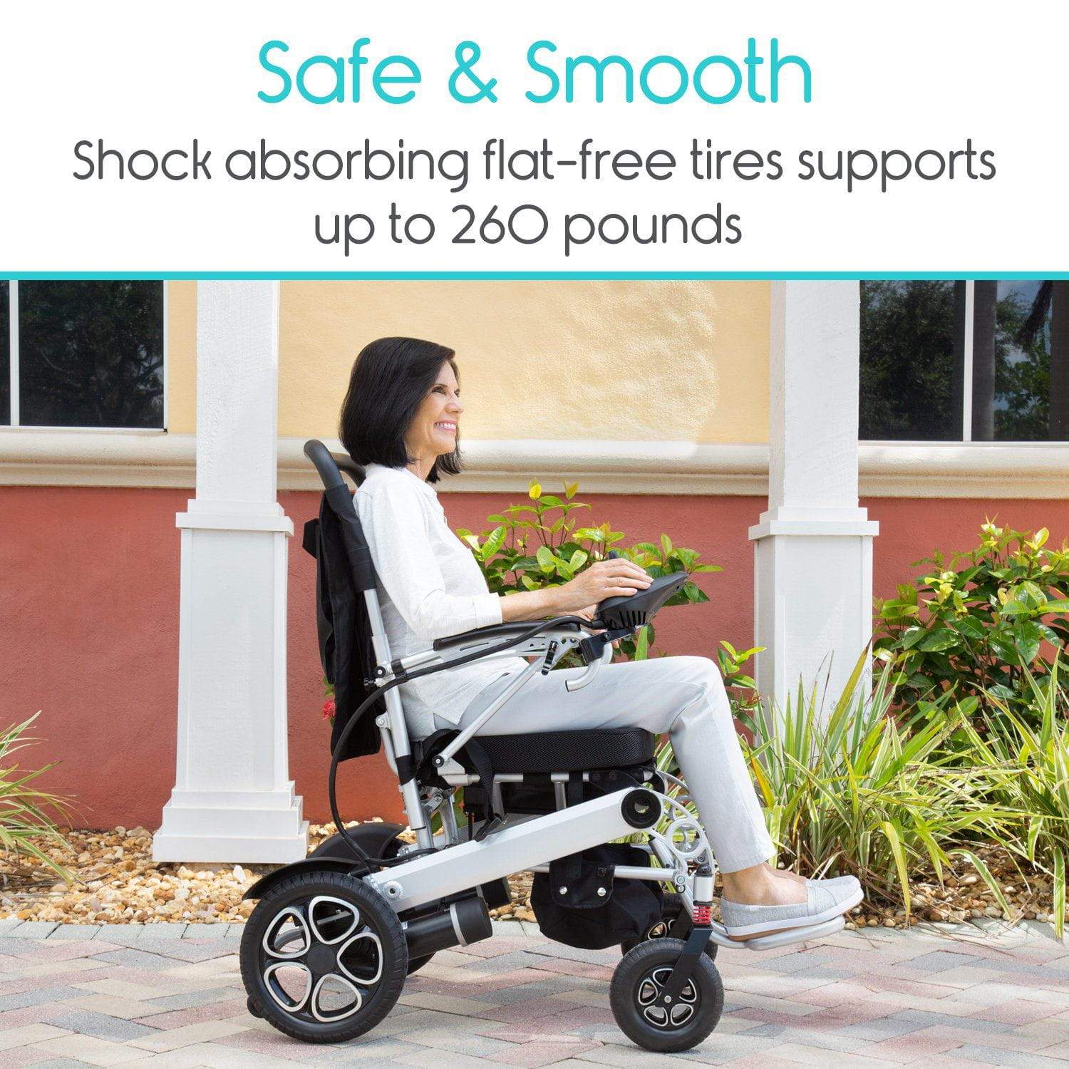 A person sits in the Vive Health Power Wheelchair, equipped with dual motors and joystick control, on a paved path. The text above states, "Safe & Smooth: Shock-absorbing flat-free tires support up to 260 pounds." Plants and a peach-colored wall provide the background scenery.